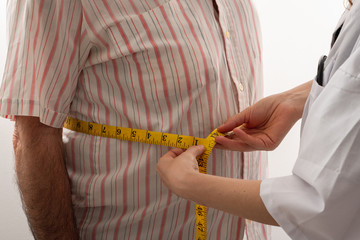 Wall Mural - young female doctor is measuring senior man's body circumference 