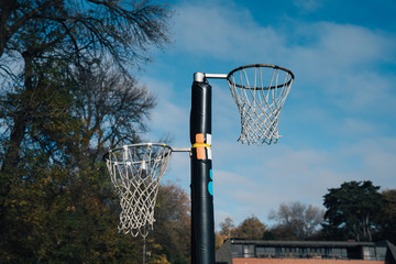 Wall Mural - Netball goal ring and net against a blue sky and clouds at Hagley park, Christchurch, New zealand.