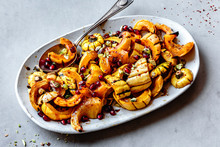 Roasted Delicata Squash With Pomegranate And Pistachios On A Plate.