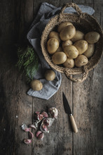 Overhead View Of Potatoes And Garlic Cloves On Wooden Table