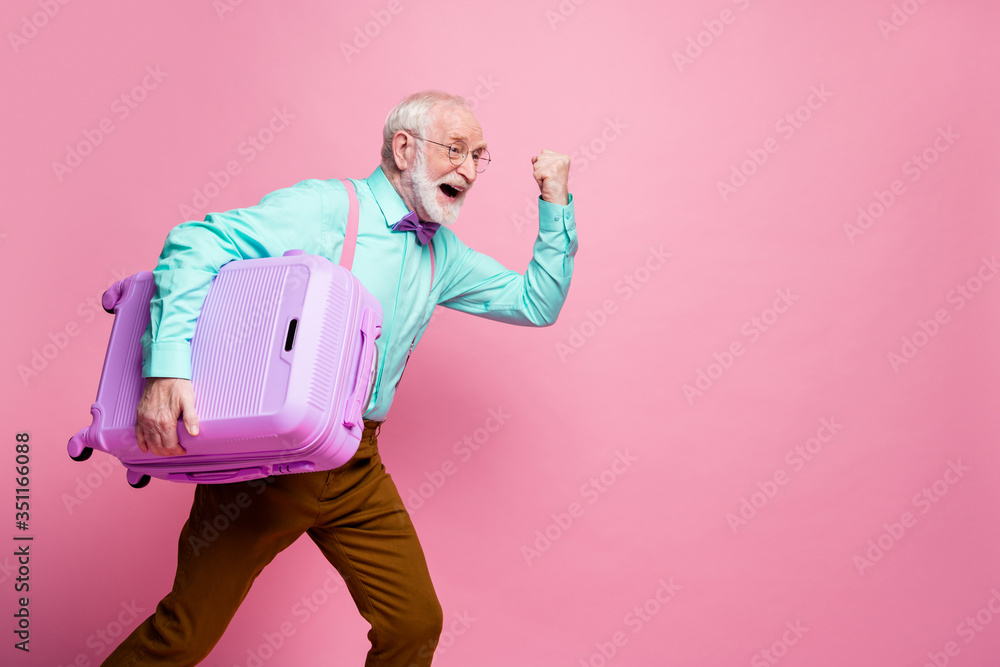 Profile side photo delighted crazy retired man win relax summer lottery hold big lugagge run fast terminal check-in wear teal turquoise shirt brown pants isolated pink color pastel background - obrazy, fototapety, plakaty 