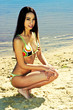 Woman in bikini squatting on the beach