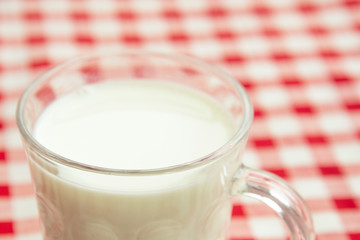 fresh milk in a mug on a red and white tablecloth