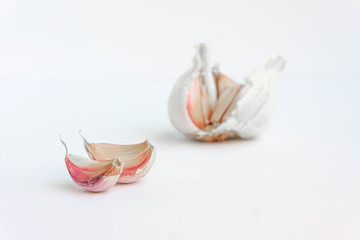 Detail of two raw garlic cloves isolated on white. Close up view.