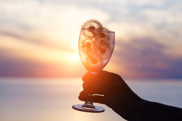 Wall Mural - magical spiritual sunrise or sunset and glass of beautiful dandelion flowers in young woman's hand, dreams, soul, purity and freedom concept