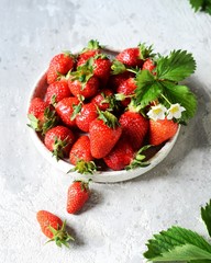 Wall Mural - Fresh strawberries in a bowl on a gray background, still life