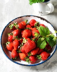 Wall Mural - Fresh strawberries in a bowl on a gray background, still life