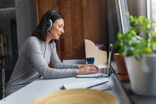 Photographie Young Woman Sitting in front of Laptop Computer at Home