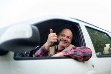 Hispanic Man Driving A Car And Showing Thumbs Up