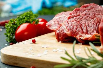 Slice of raw beef fillet on wooden board