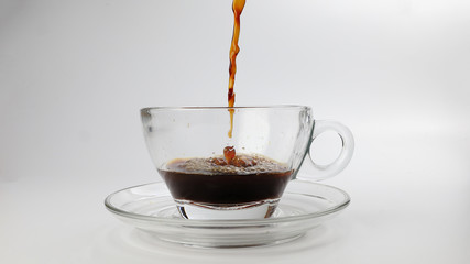 dark Coffee poring dripping splash shadow liquid swirl in glass cup saucer on white background stop motion