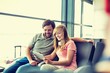 © MDBPIXS - Portrait of young beautiful teenage girl showing digital tablet to her father while sitting and waiting for their flight in airport