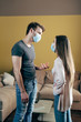 © LIGHTFIELD STUDIOS - man in medical mask gesturing while quarreling with girlfriend at home
