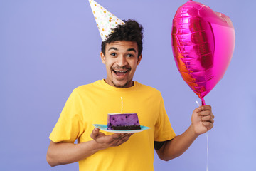 Canvas Print - Photo of african american man in party cone holding cake and balloon