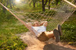 © cenchild - man relax in hammock garden. summer vibes in green forest