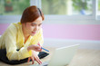 © sutthichai - asian woman work at home with laptop laydown on floor with happiness and joyful