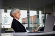 © Westend61 - Senior businesswoman sitting at desk in office looking at distance