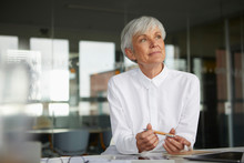 Portrait Of Pensive Senior Businesswoman At Desk In Her Office