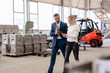 © Westend61 - Businessman and young woman with tablet walking and talking in a factory
