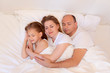 © Анна Александровна Х - Happy family, mom, dad, daughter sleep in bed in the bedroom at home