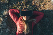 © Westend61 - Young woman with VR goggles lying on ground in nature