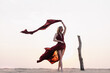 © Denis - Silhouette of a girl in a red dress at sunset in the desert