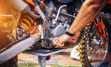 Motor Mechanic Working On Motorcycle Mx Engine In Mechanics Garage. Repair Service. Authentic Close-up Shot