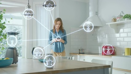 Internet of Things Concept: Young Woman Using Smartphone in Kitchen. She controls her Kitchen Appliances with IOT. Graphics Showing Digitalization Visualization of Connected Home Electronics Devices