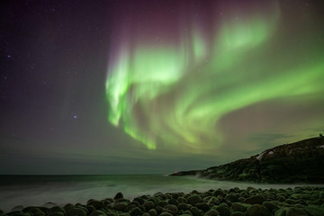 colorful northern light aurora borealis with purple, red, green and blu flames over the sky in icela