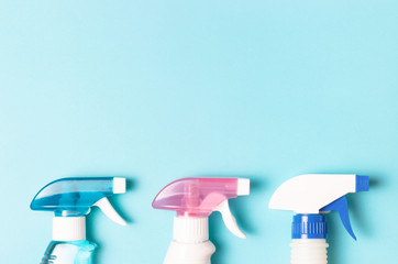 Three bottles of spray on a blue background with copy of the travel, the concept of cleaning