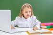 © Ermolaev Alexandr - Smart young girl uses laptop in a school