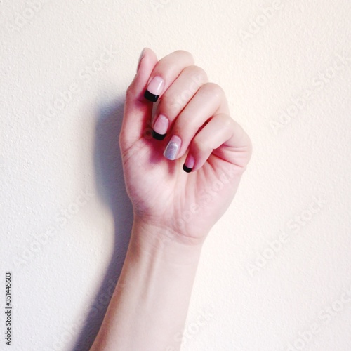 Cropped Image Of Hand With Nail Polish Against Wall