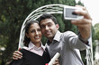 © ImageHit - Man taking picture with woman in graduation gown