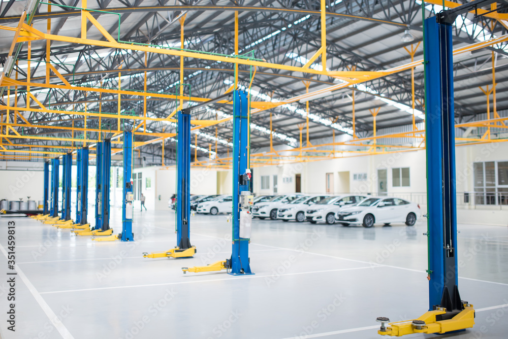 The electric lift for cars in the service put on the epoxy floor in new car factory service , Car repair service center background for industry