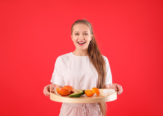 Wall Mural - Young woman with healthy products on color background. Diet concept