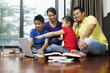© ImageHit - Family using laptop together