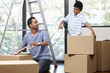 © ImageHit - Man and boy sealing cardboard boxes with adhesive tape