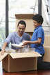 © ImageHit - Man and boy packing box together