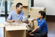 © ImageHit - Man and boy packing box together