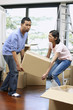 © ImageHit - Man and woman lifting cardboard box together