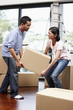 © ImageHit - Man and woman lifting cardboard box together