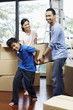 © ImageHit - Boy helping parents lifting cardboard box together