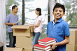 © ImageHit - Boy with a stack of books, man and woman packing in the background