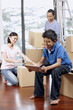 © ImageHit - Boy using digital tablet, man and woman packing in the background