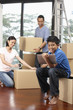© ImageHit - Boy using digital tablet, man and woman packing in the background