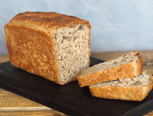 Freshly baked diet rye bread on a wooden table with a gray background.