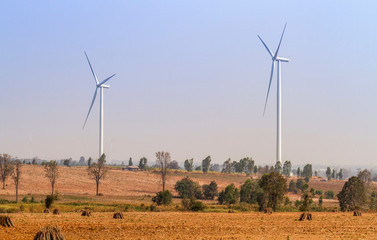 Wind turbines power generator over blue sky at farmer field