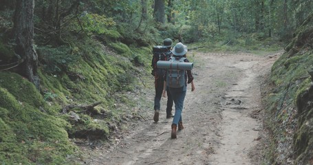 young man and woman hiking in forest