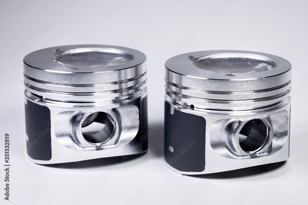 Piston Combuster Close-up of two new internal combustion engine piston on a gray ...