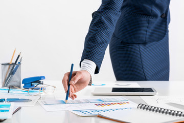 Wall Mural - Businesswoman standing near office desk with pen